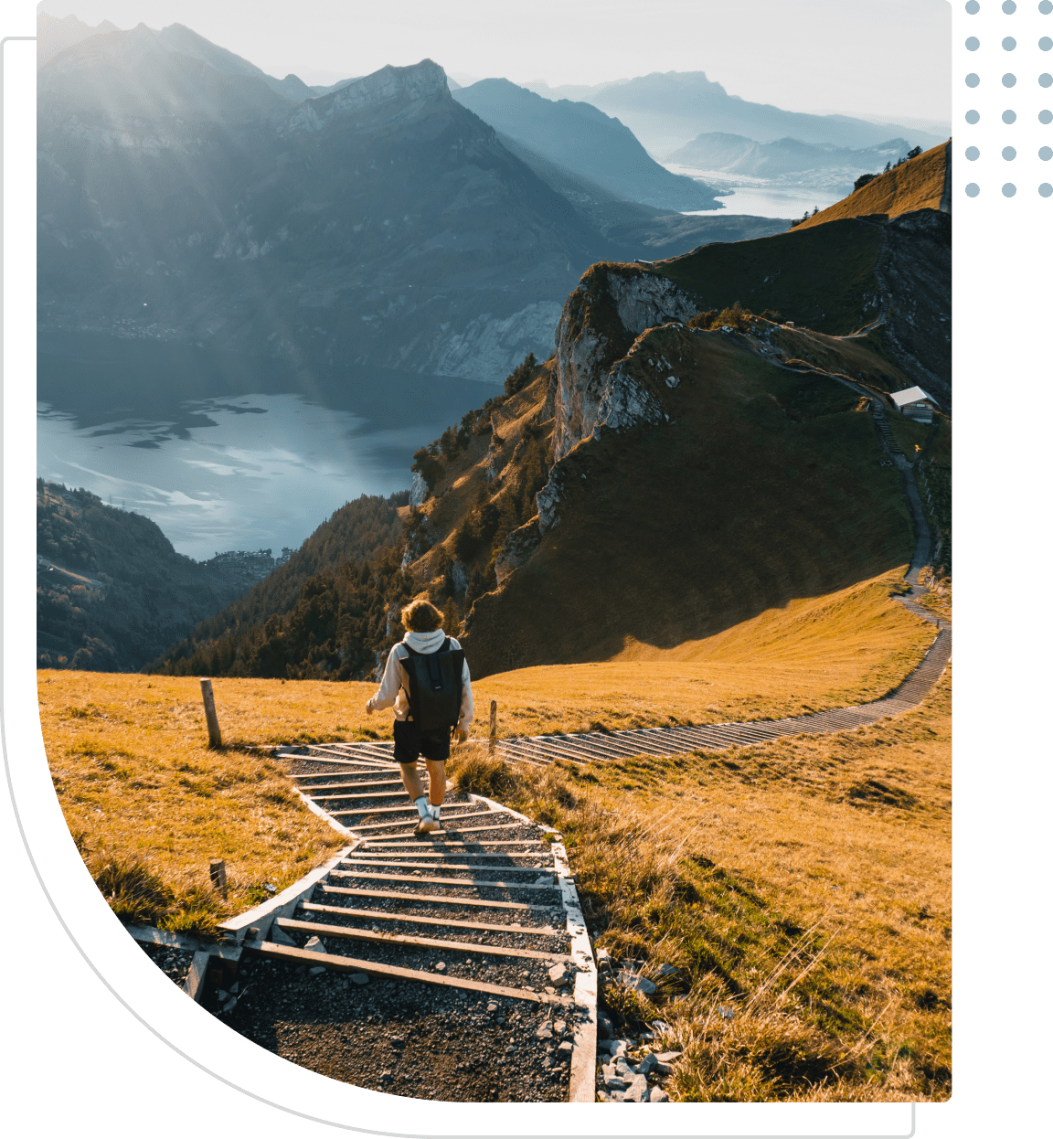 Hiker descending mountain path with scenic view.
